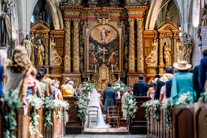 Mariés devant le retable doré pendant la cérémonie religieuse à l'église