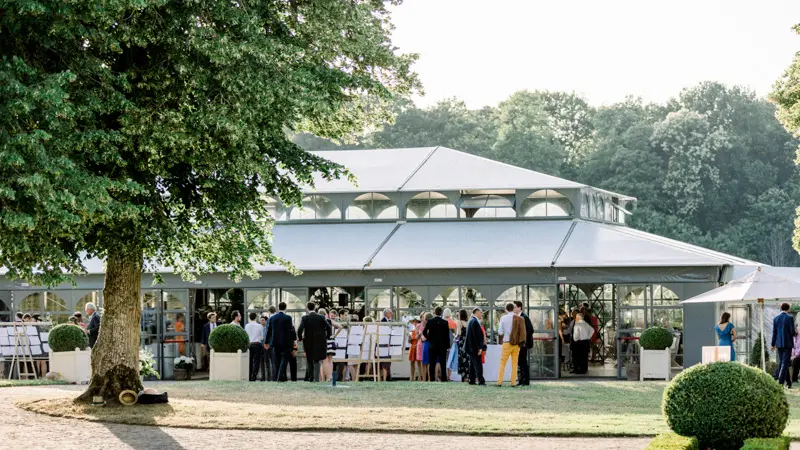 Invités réunis devant l'orangerie sous les arbres du Château d'Argeronne