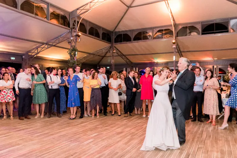 Invités en cercle autour de la mariée qui ouvre le bal dans l'orangerie