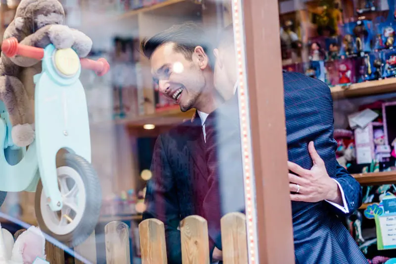 The grooms embracing, reflected in a toy shop window in Bordeaux