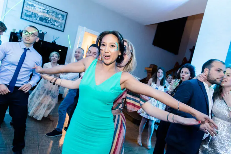 A guest in a turquoise dress dancing with open arms on the dance floor in Lanton