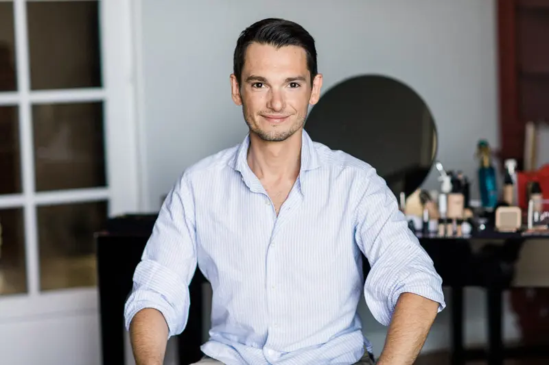 Portrait of a smiling groom in a light shirt getting ready at Villa La Tosca