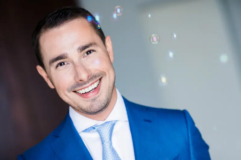 Portrait of a smiling groom in a royal blue suit and sky-blue tie