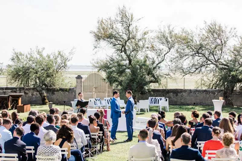 The grooms' outdoor ceremony in the Villa La Tosca garden with guests seated
