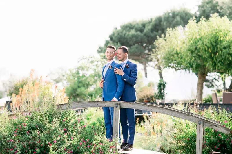 The two grooms on a wooden footbridge in the villa's flowering garden
