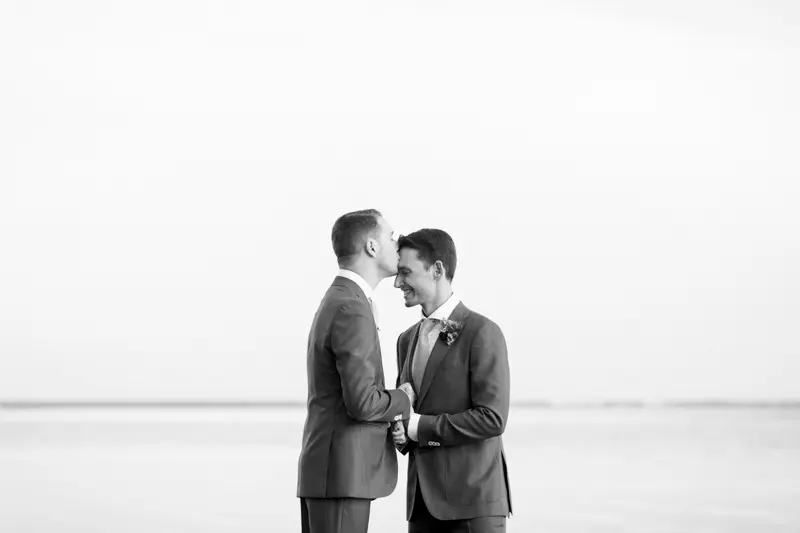 The two grooms face to face on an Arcachon Bay beach, in black and white