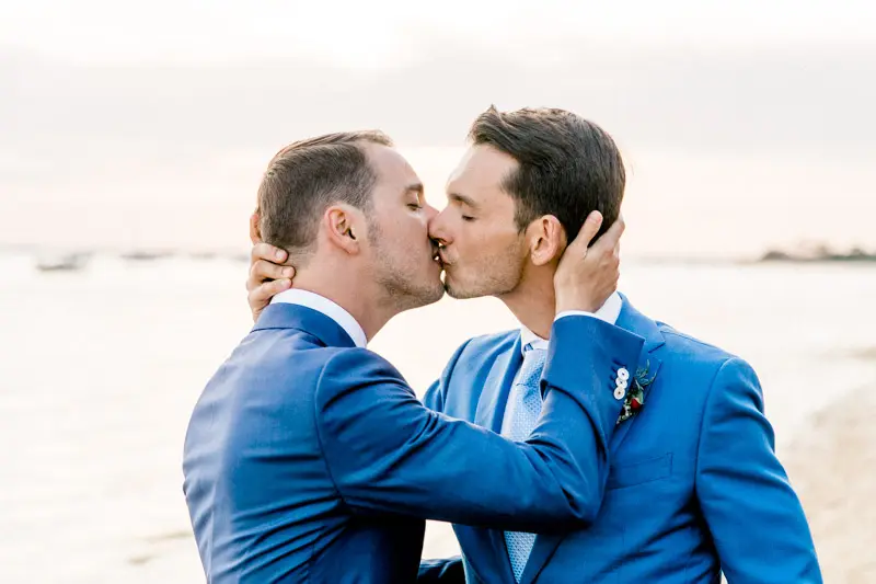 The two grooms kissing at sunset on an Arcachon Bay beach