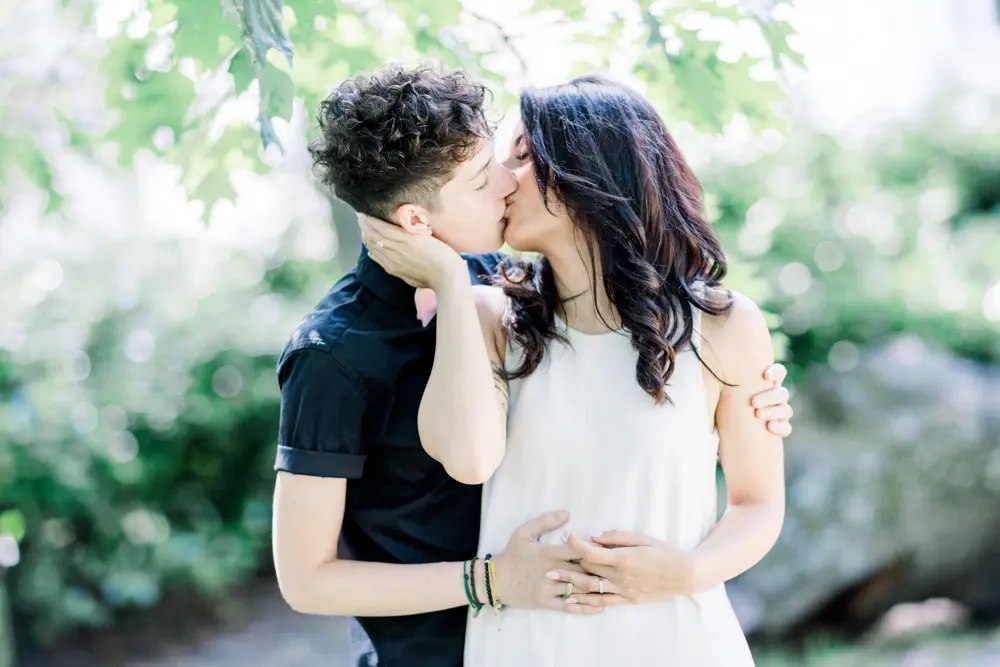 A tender kiss beneath the foliage of the Parc Bordelais in Bordeaux