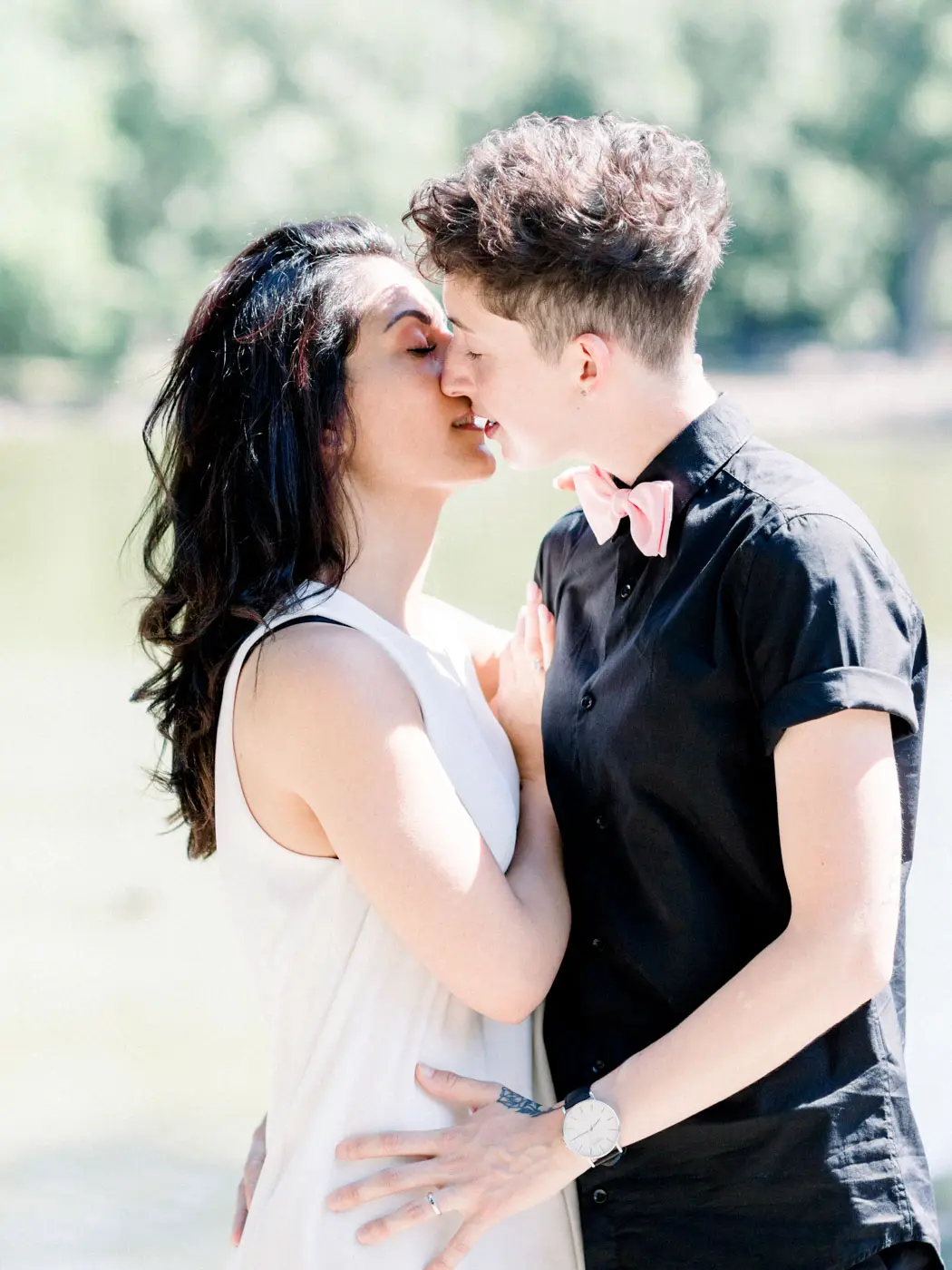 Kissing by the pond in the Parc Bordelais in soft summer light