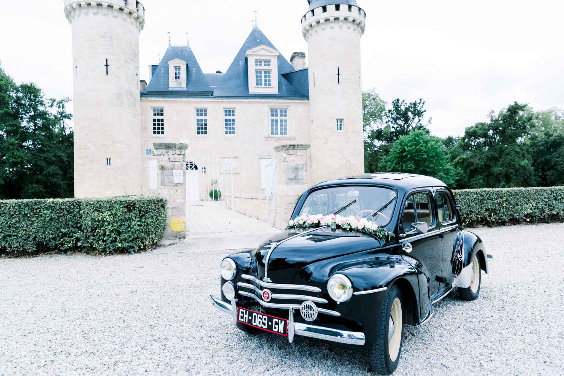 Black vintage car parked in front of Château d'Agassac
