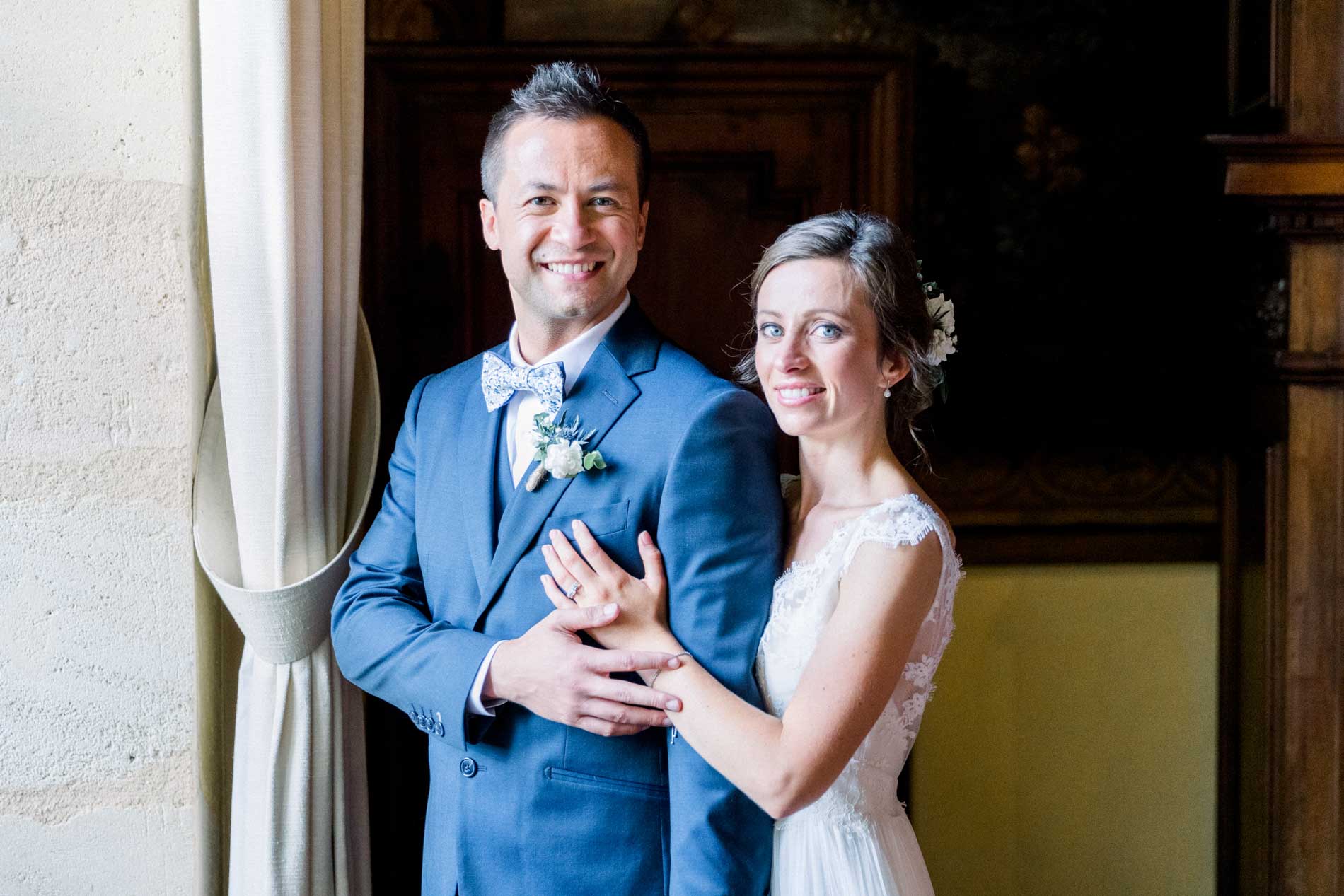 The smiling couple framed by a château doorway