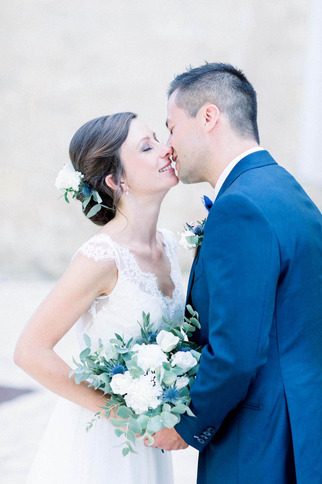 Close-up of the couple kissing, white and green bouquet in hand
