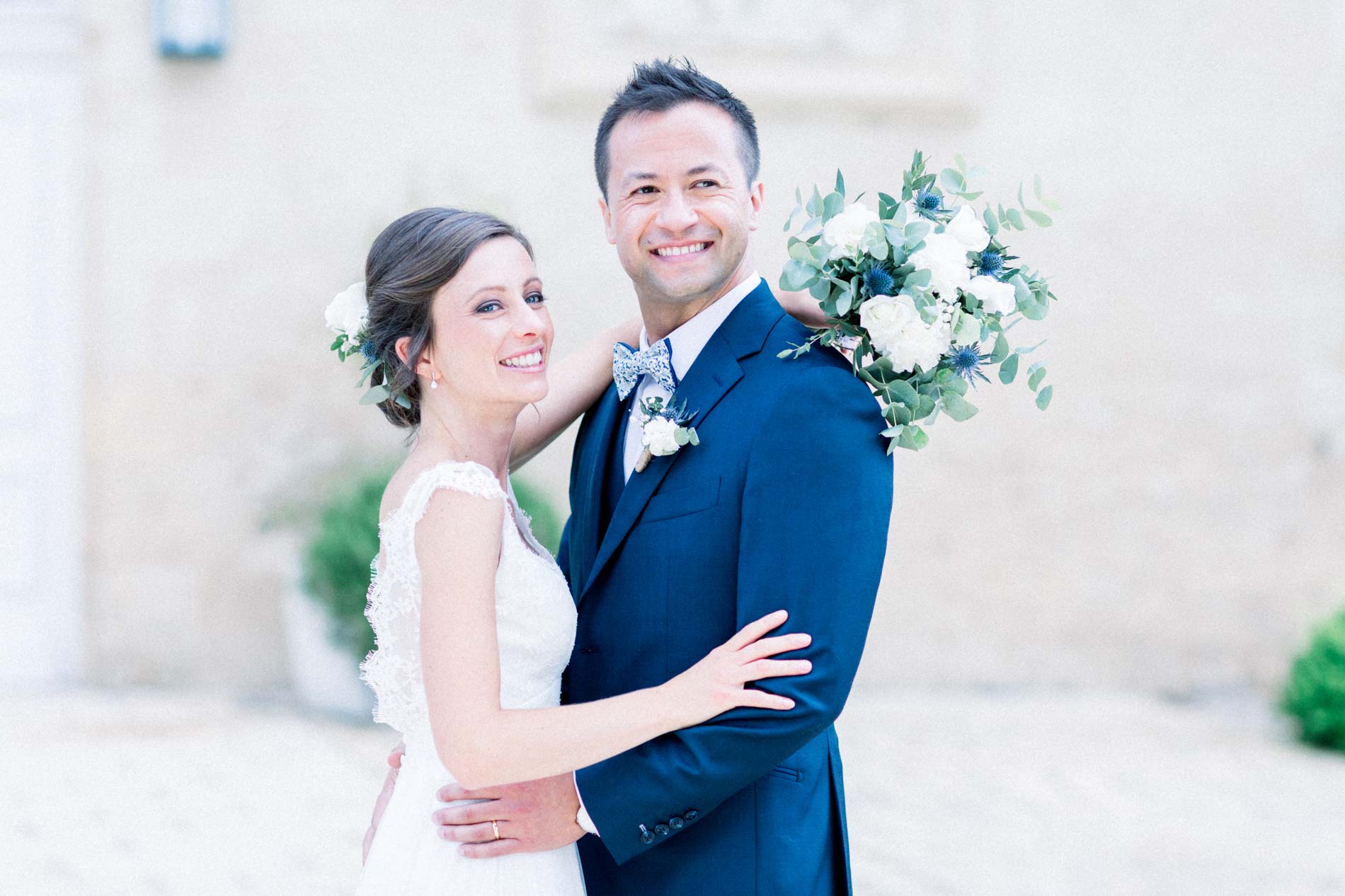 The couple embracing and smiling in the stone courtyard