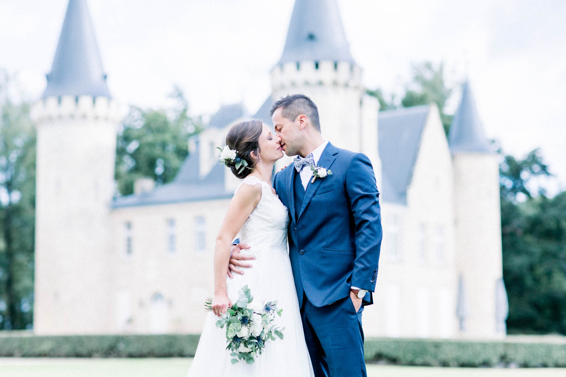 The couple kissing in front of the turrets of Château d'Agassac