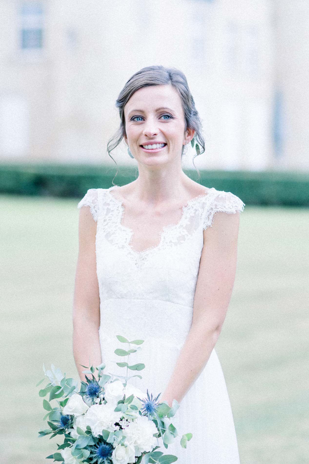 Portrait of the smiling bride holding her blue and white bouquet