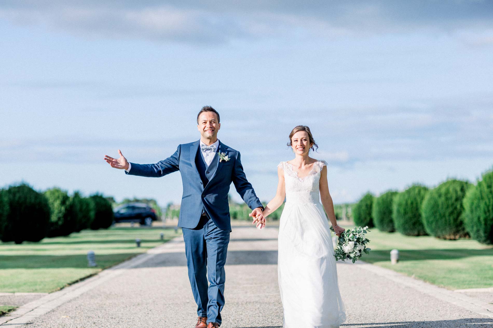 The newlyweds walking happily along the drive of Château d'Agassac