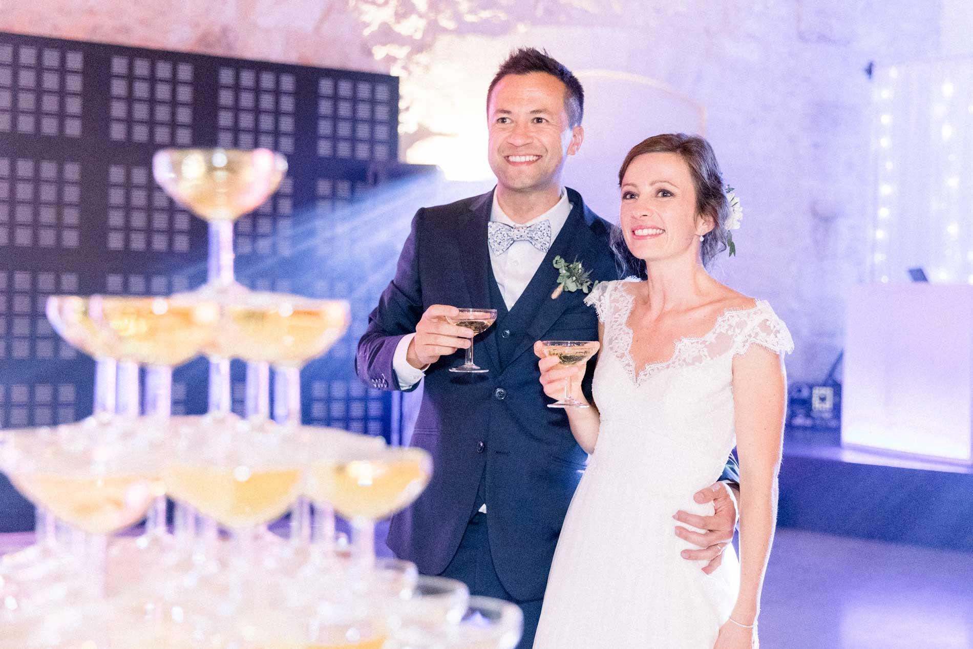 The newlyweds next to a champagne tower