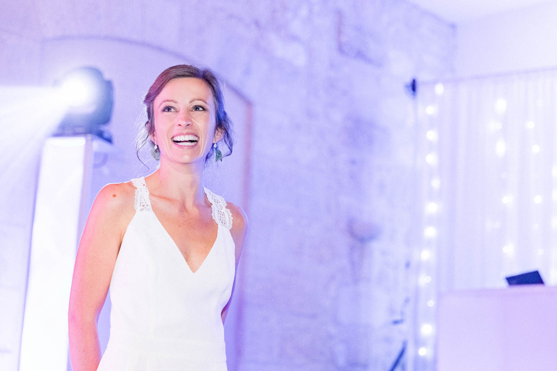 The bride smiling under the party lights
