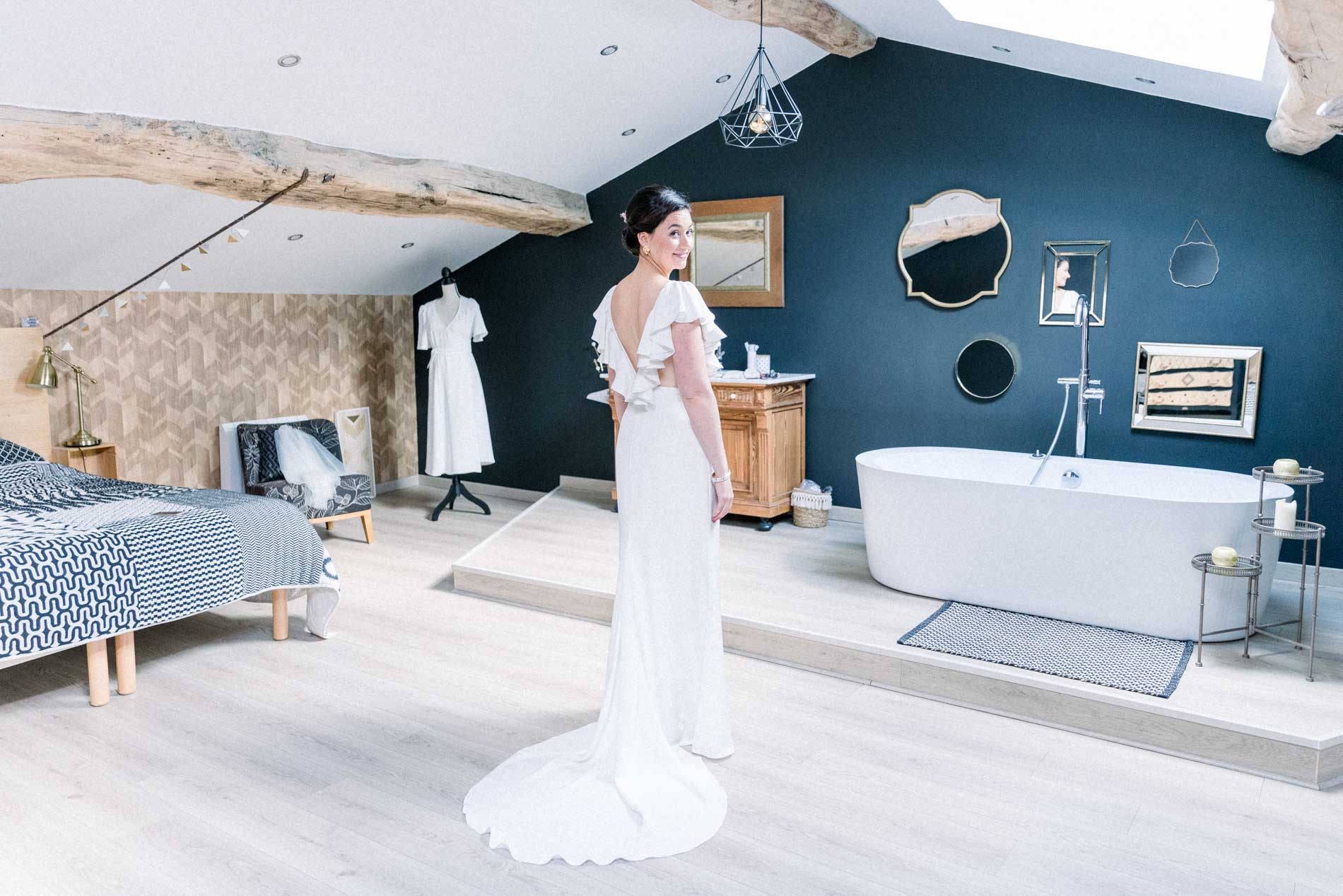 The bride in her gown in the suite with a freestanding bath at Château Saint-Georges