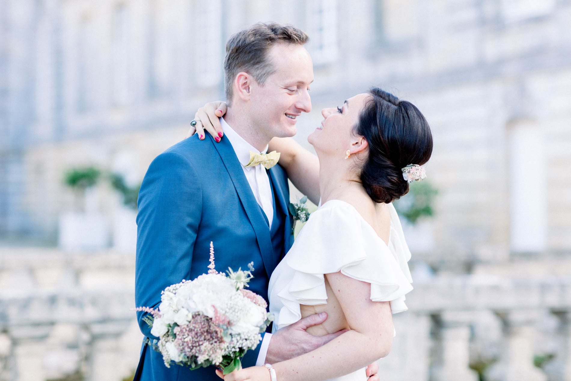 The bride kissing the groom in front of the Château Saint-Georges facade