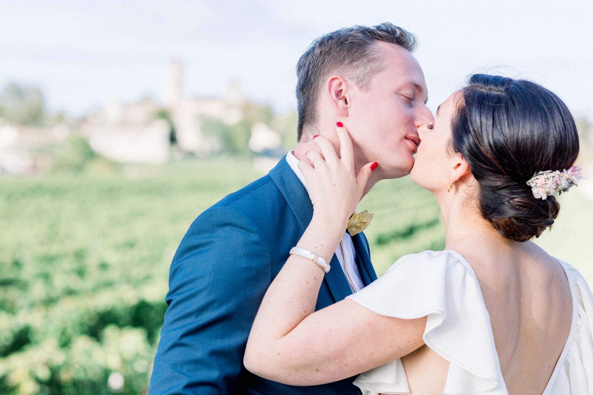The bride and groom kissing tenderly in front of the Saint-Émilion vines