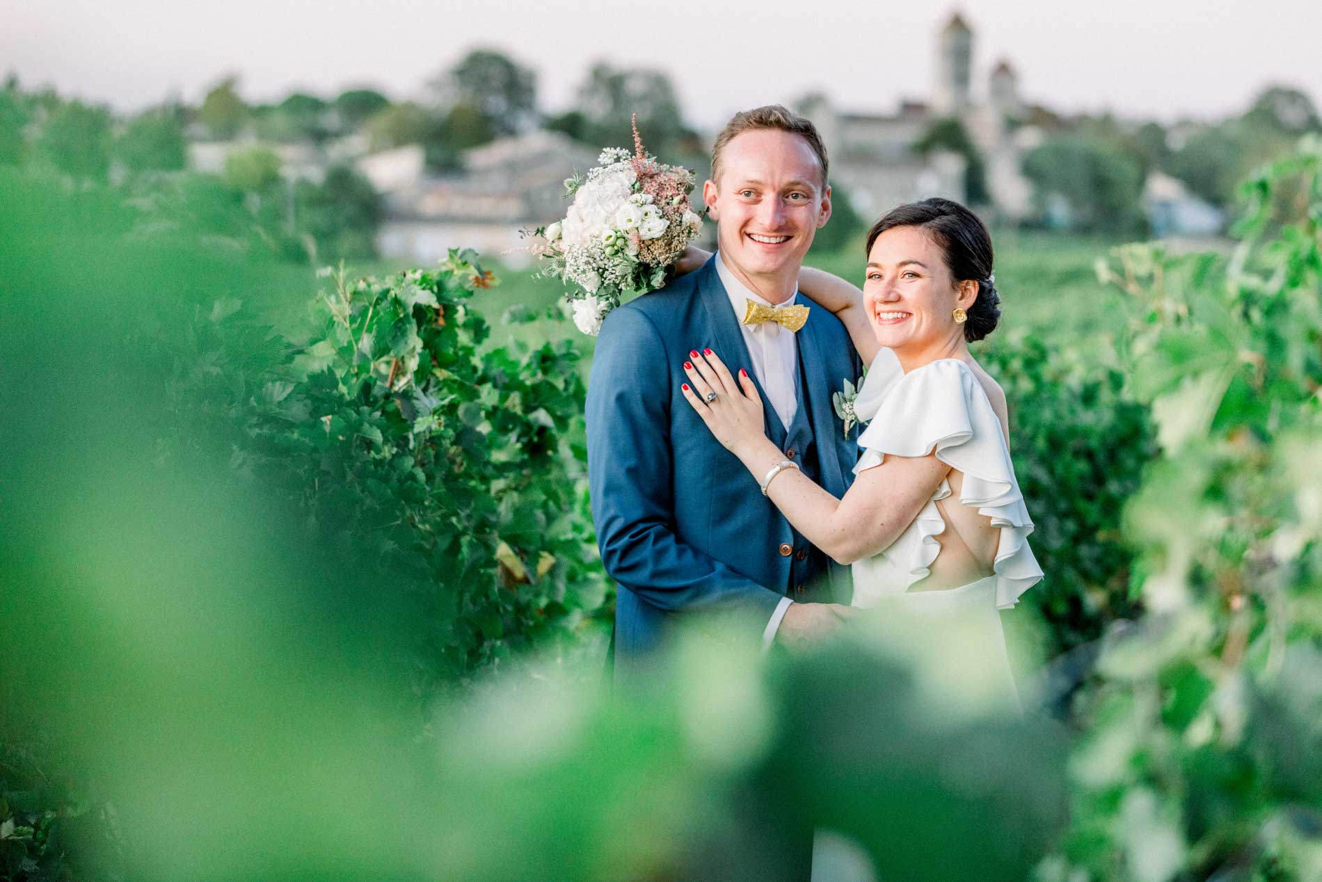 The bride and groom smiling in an embrace among the vines at day's end