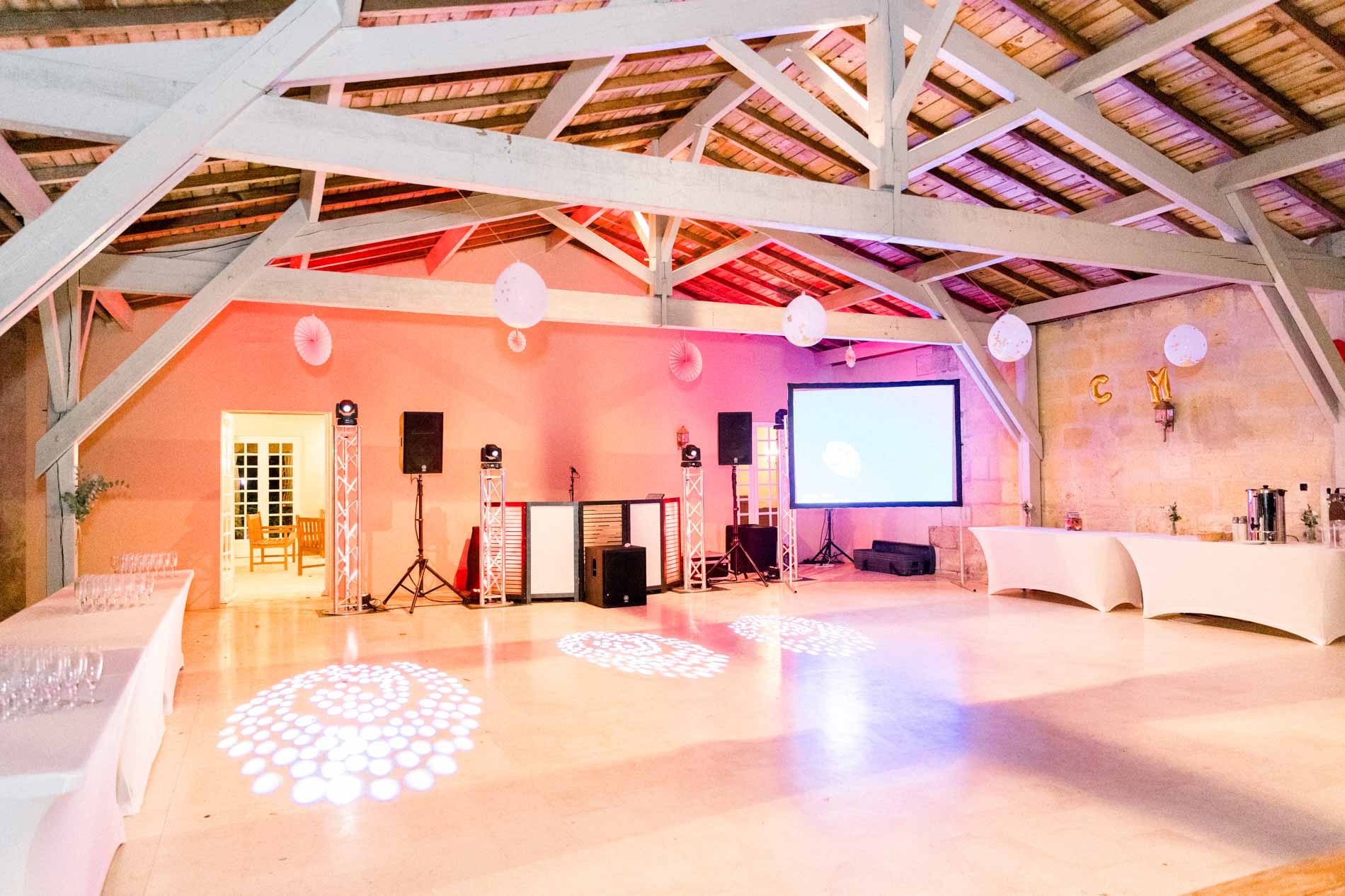 Dance floor ready under the beams with lighting and a projection screen