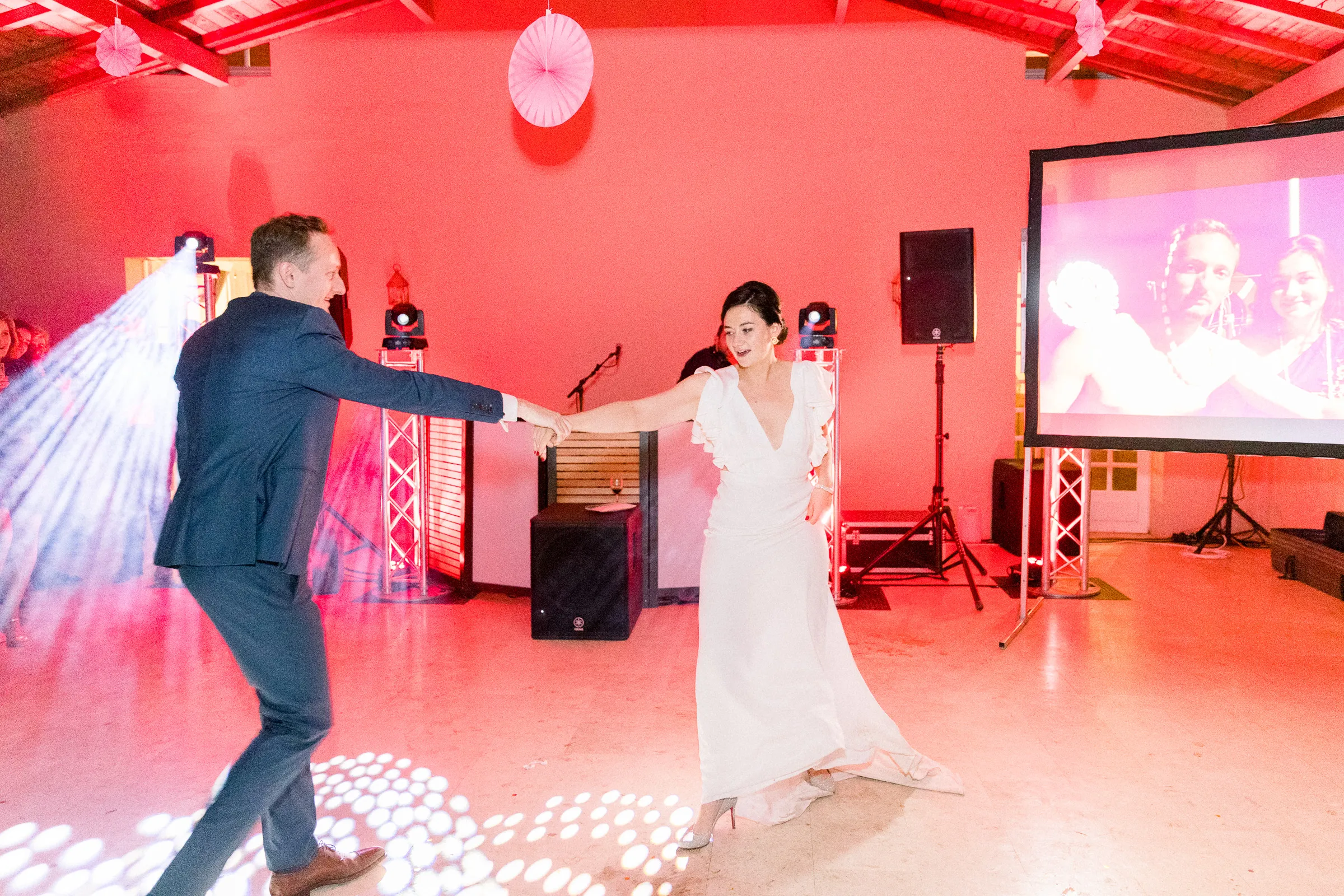 Première danse des mariés sur la piste éclairée de rouge