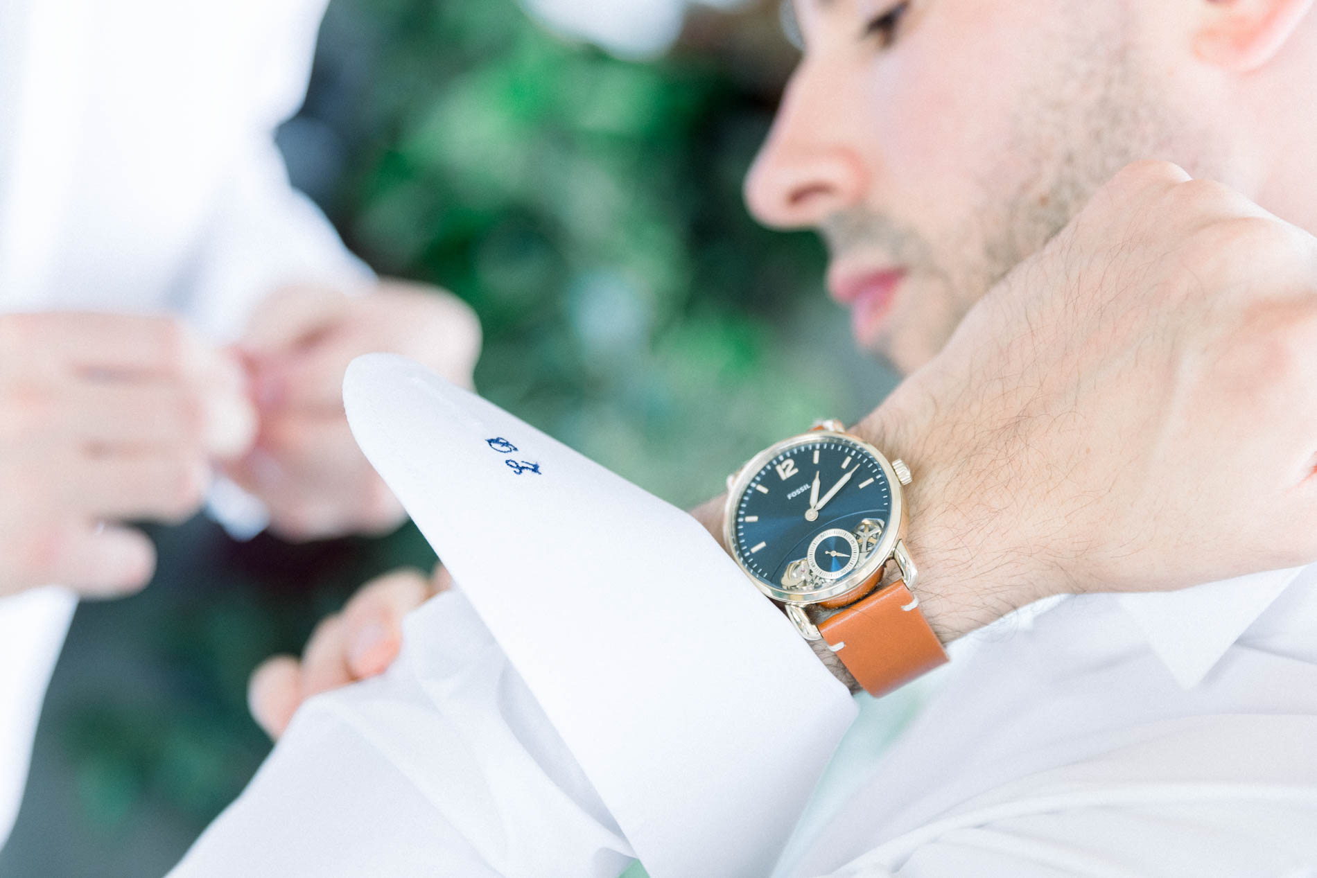 Marié ajustant le poignet de sa chemise blanche, montre au bracelet en cuir
