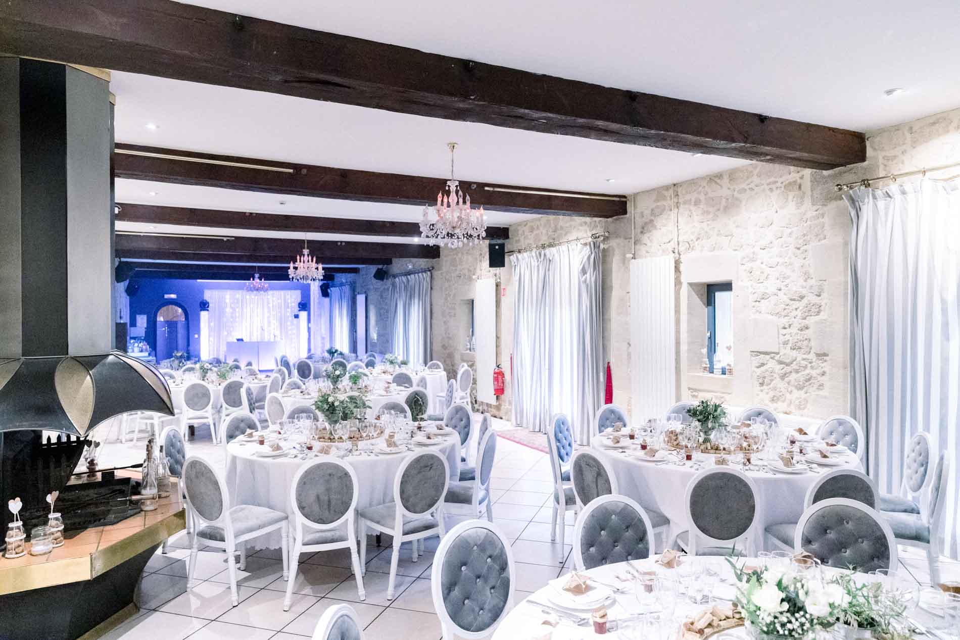 Salle de réception aux poutres et murs en pierre du Domaine de Valmont