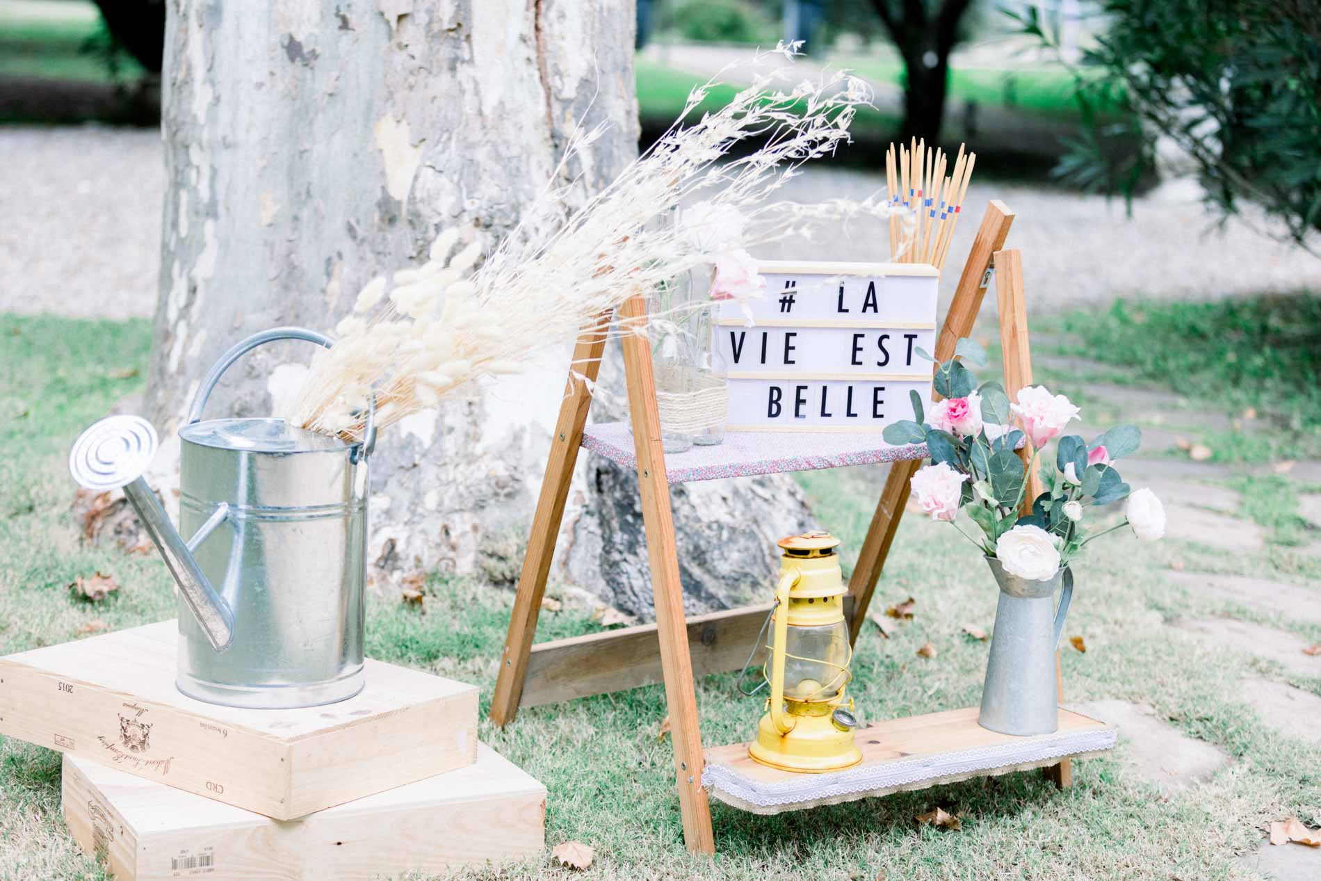 Décoration champêtre avec arrosoir, lanterne et ardoise « La vie est belle »