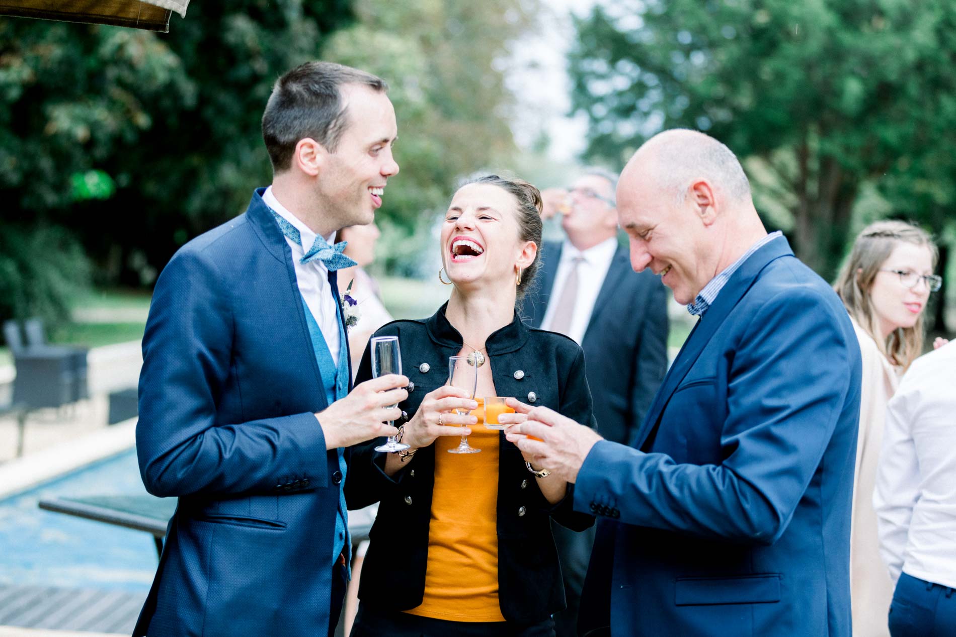Marié trinquant avec des invités pendant le vin d'honneur au bord du bassin