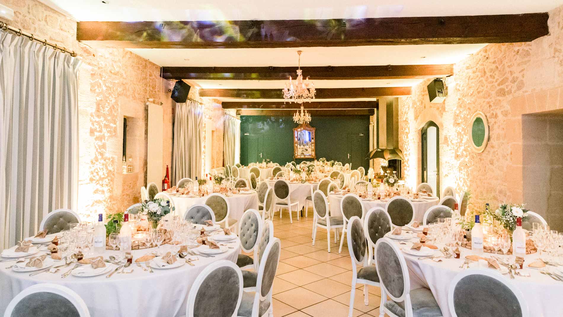 Salle de réception éclairée aux tables rondes et chaises médaillon