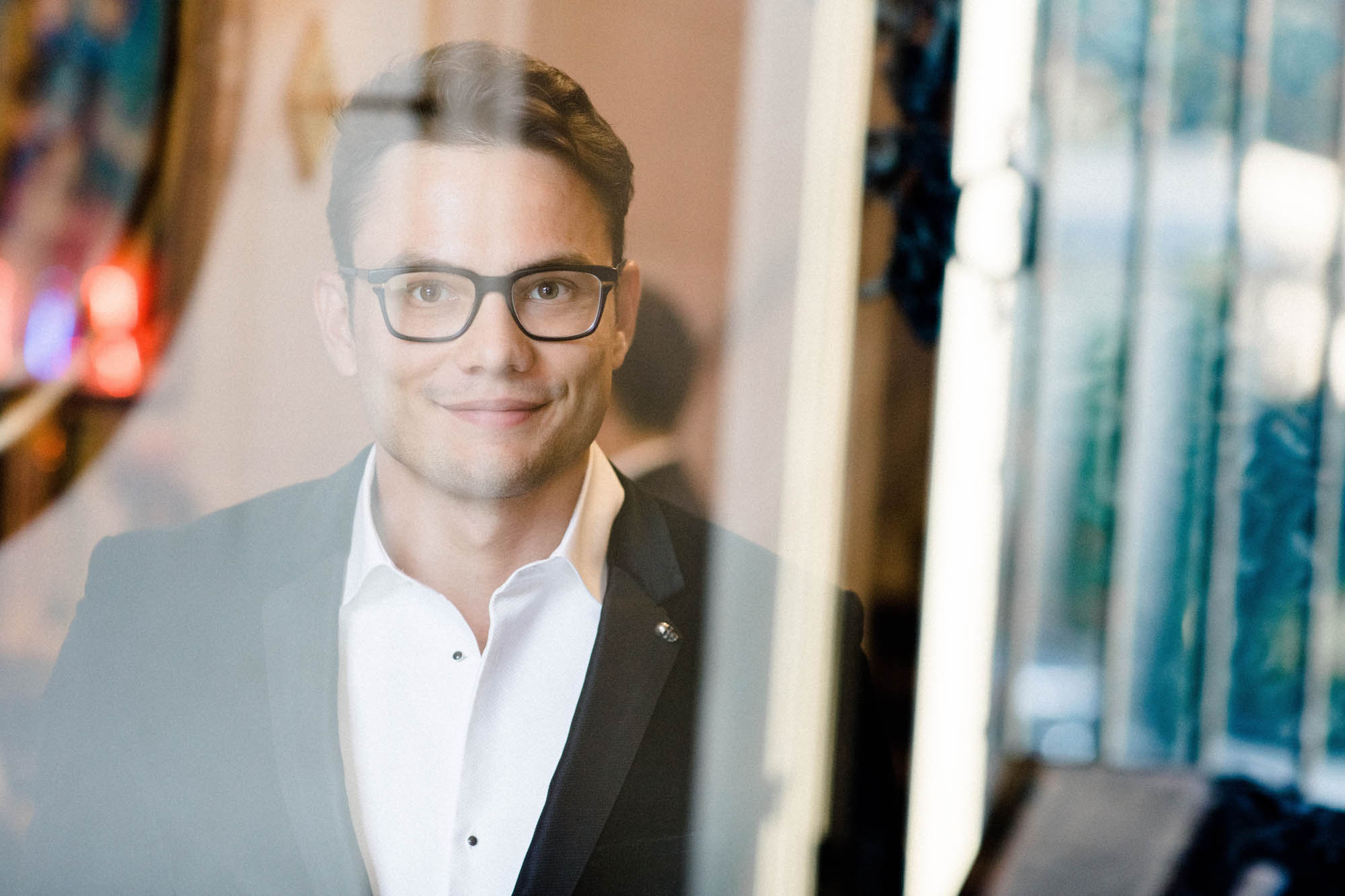 Portrait of a smiling man in glasses and a velvet jacket during the couple shoot