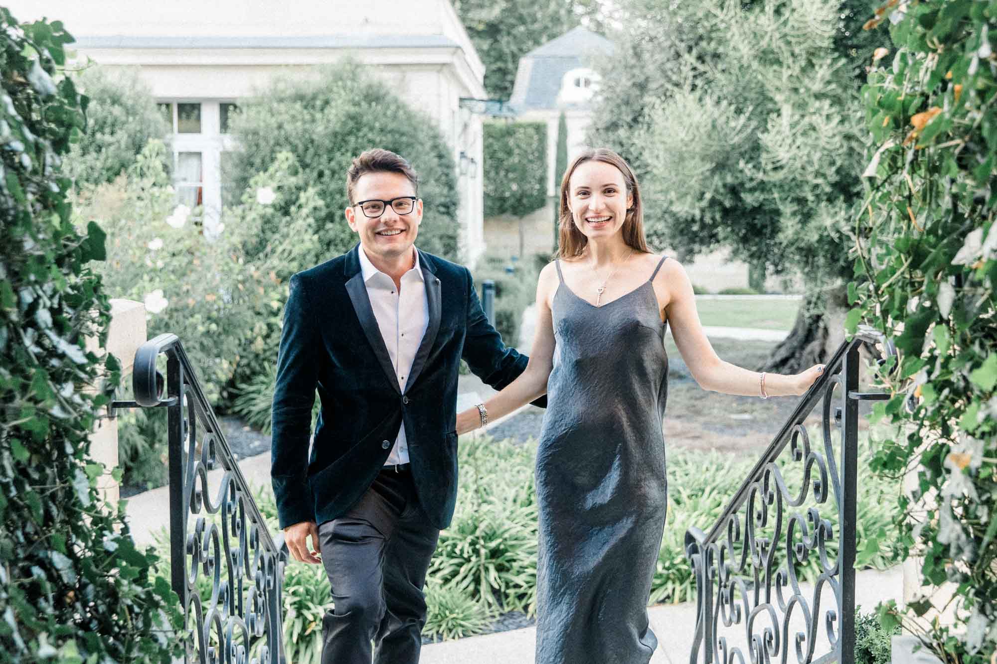 The couple walking down the wrought-iron garden steps of La Grande Maison