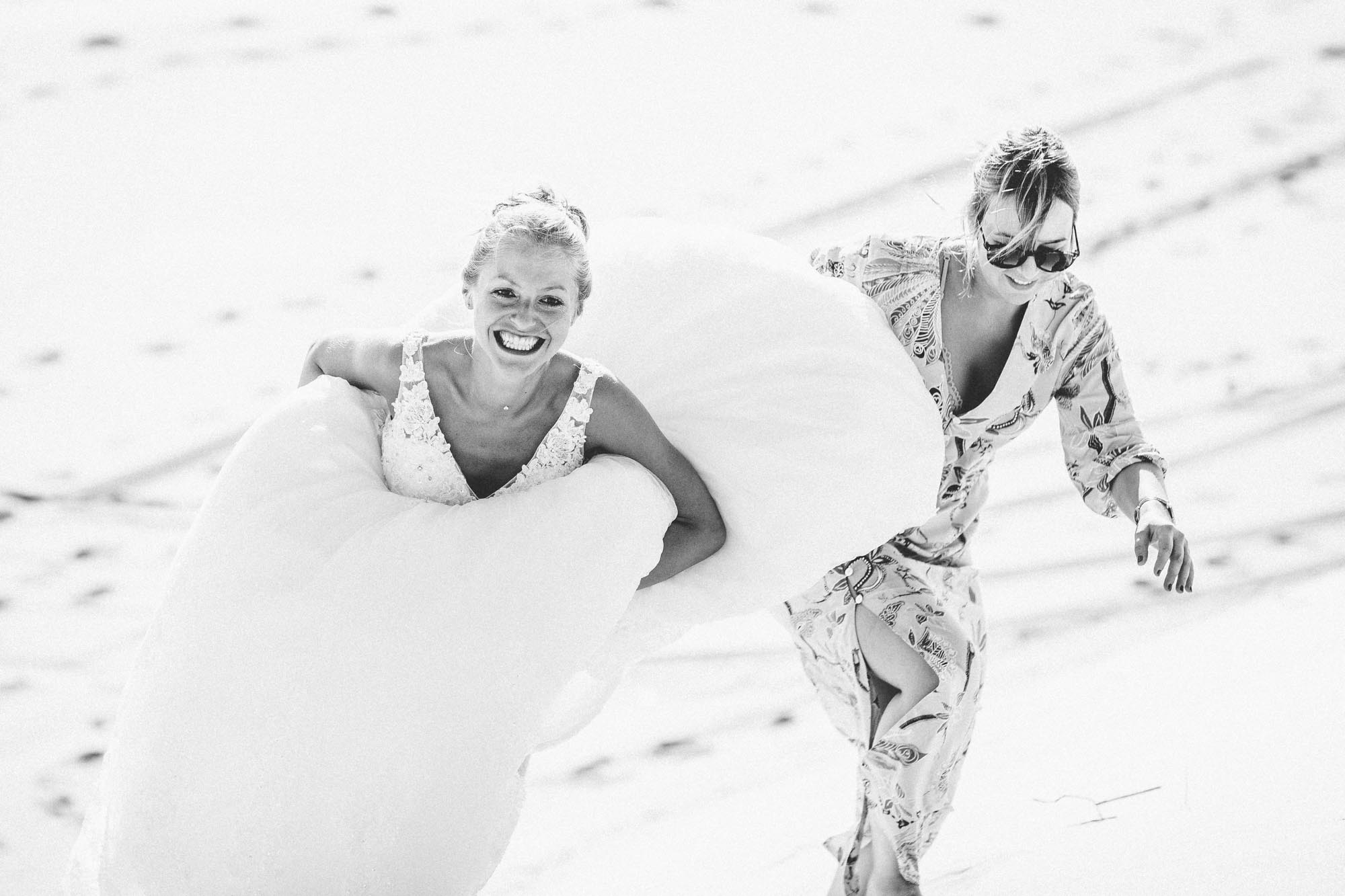 Johanna et Alexandre courent en riant dans le sable, en noir et blanc