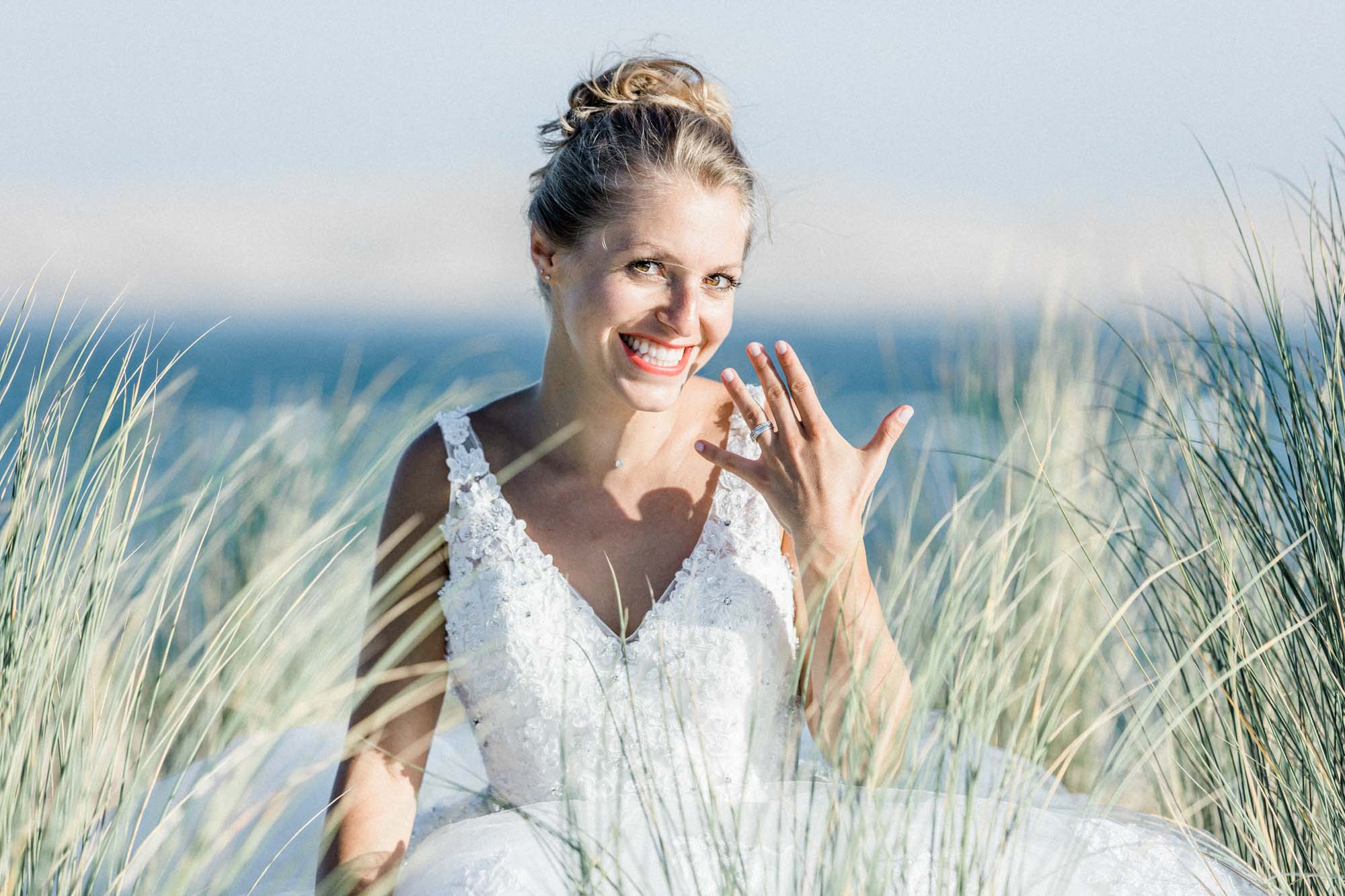 Johanna rit, assise dans les oyats, en robe de mariée