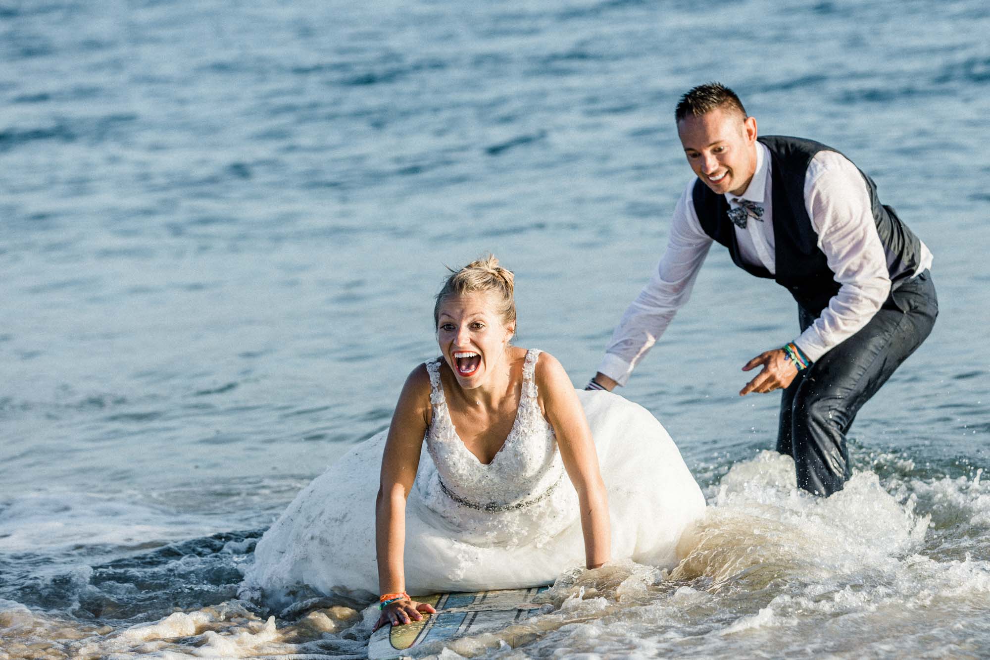 Le marié s'apprête à éclabousser la mariée assise dans l'eau