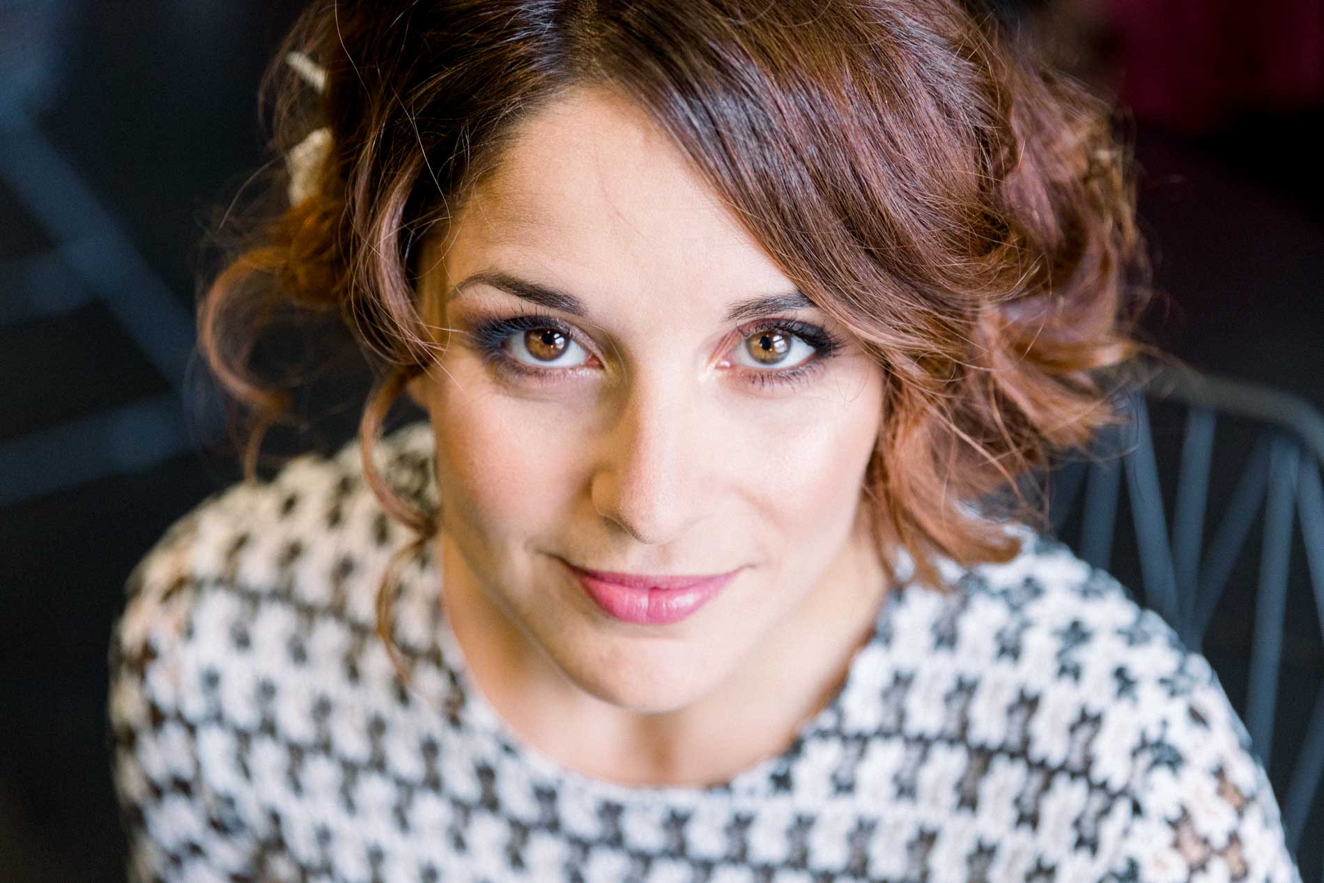 Close-up of the bride's made-up eyes, wearing her houndstooth dress