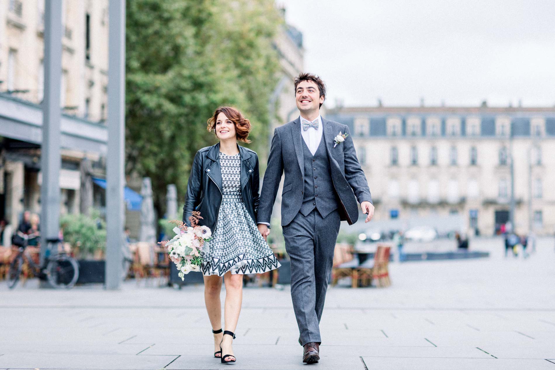 The bride and groom walking hand in hand through Bordeaux after the town hall