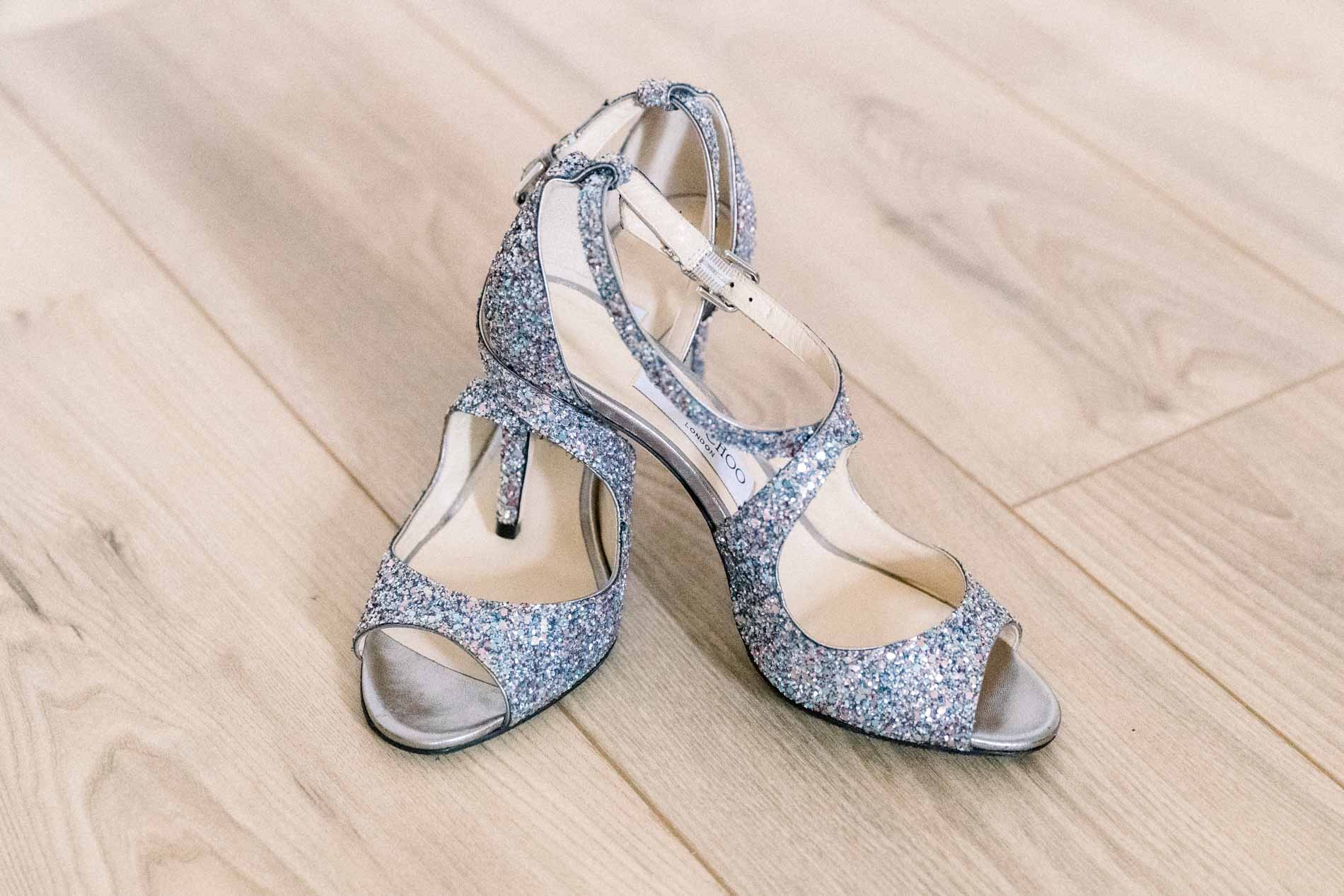 The bride's glittery silver shoes on the wooden floor