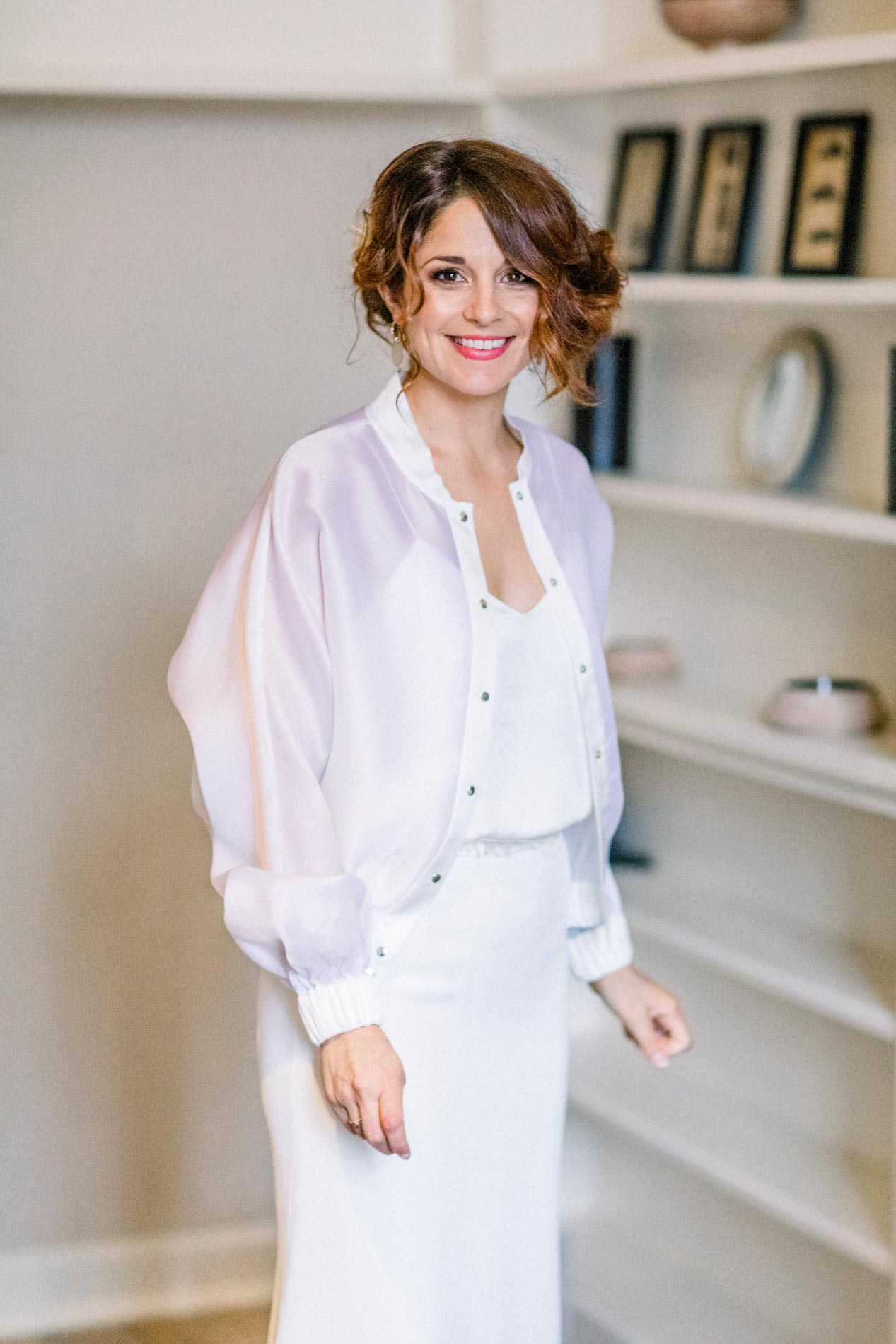 The bride in a flowing white blouse and pencil skirt for a winter wedding