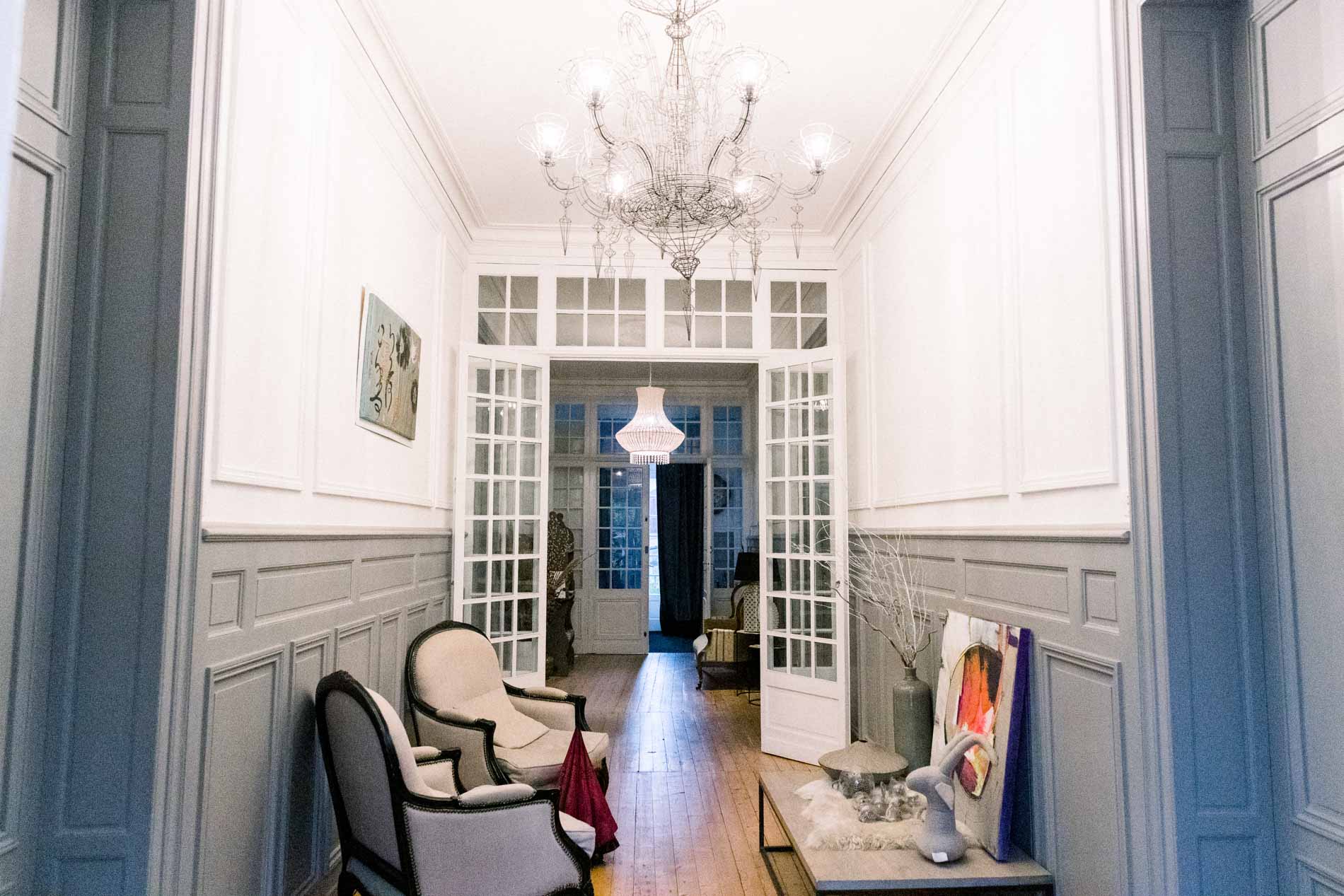 Bright corridor at the Chartreuse des Eyres with a chandelier and panelling
