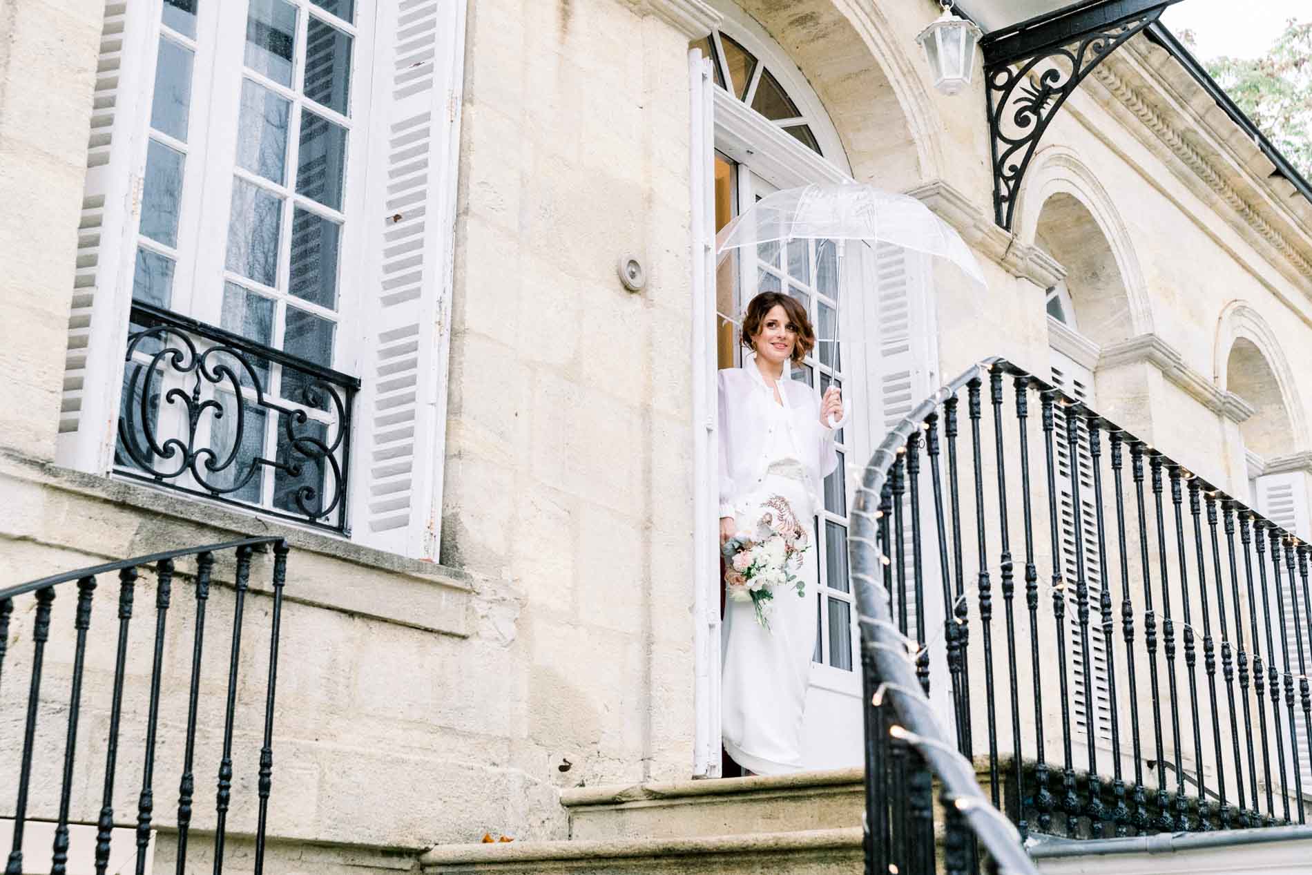 The bride stepping out onto the stone porch of the Chartreuse des Eyres