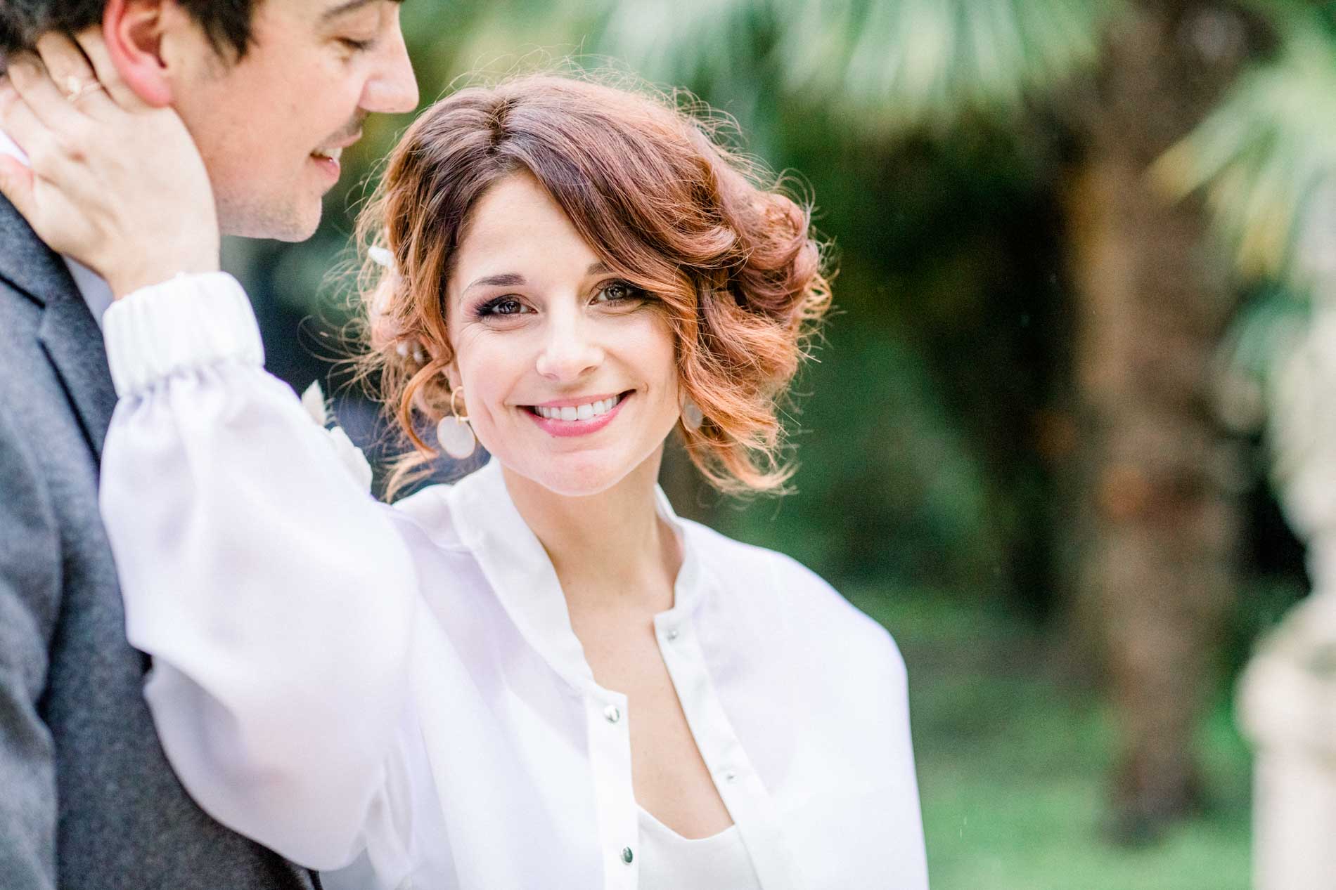 The radiant bride touching the groom's cheek in the grounds