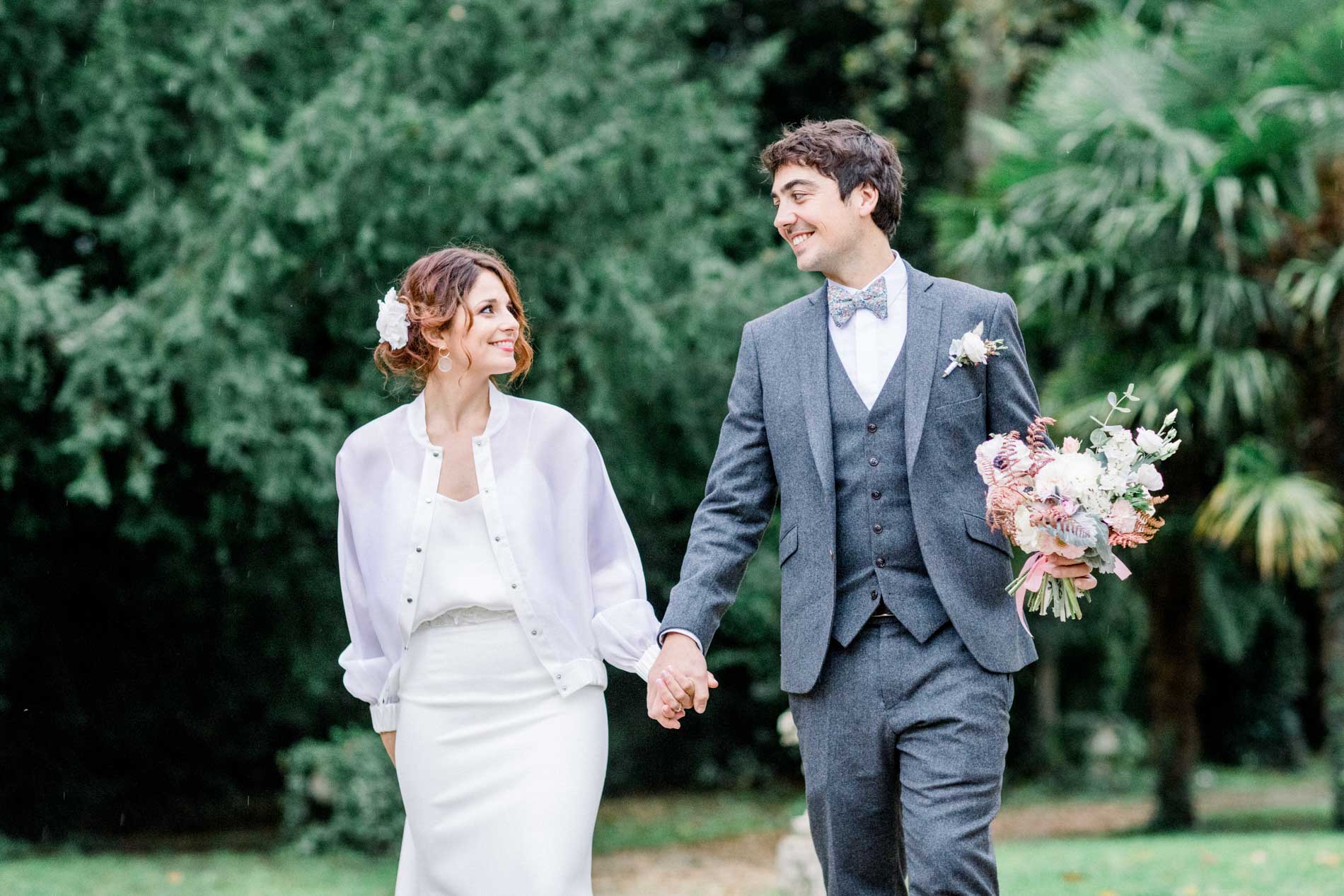 The bride and groom walking hand in hand in the Chartreuse des Eyres grounds