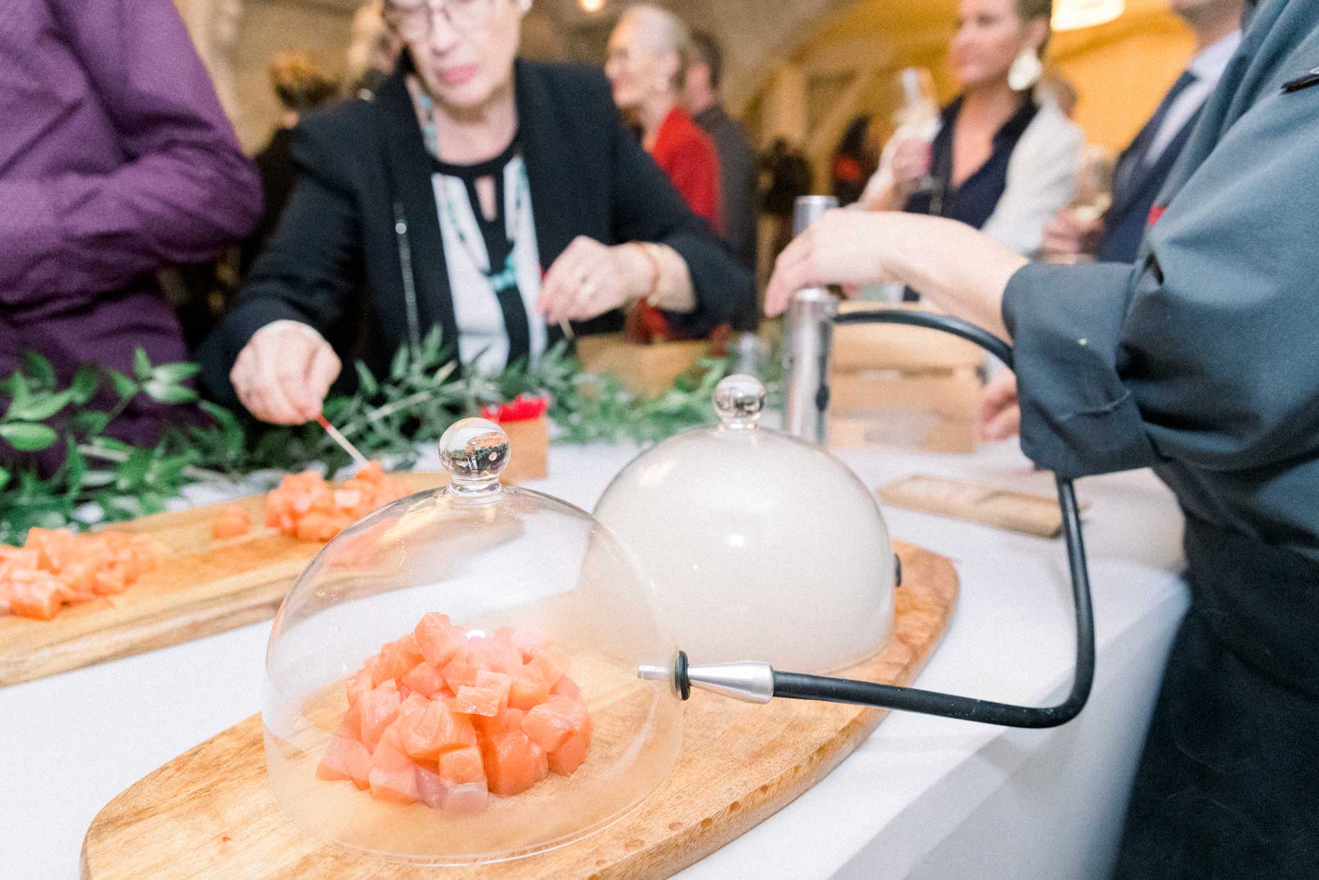 Guests helping themselves to the smoked salmon station during cocktail hour