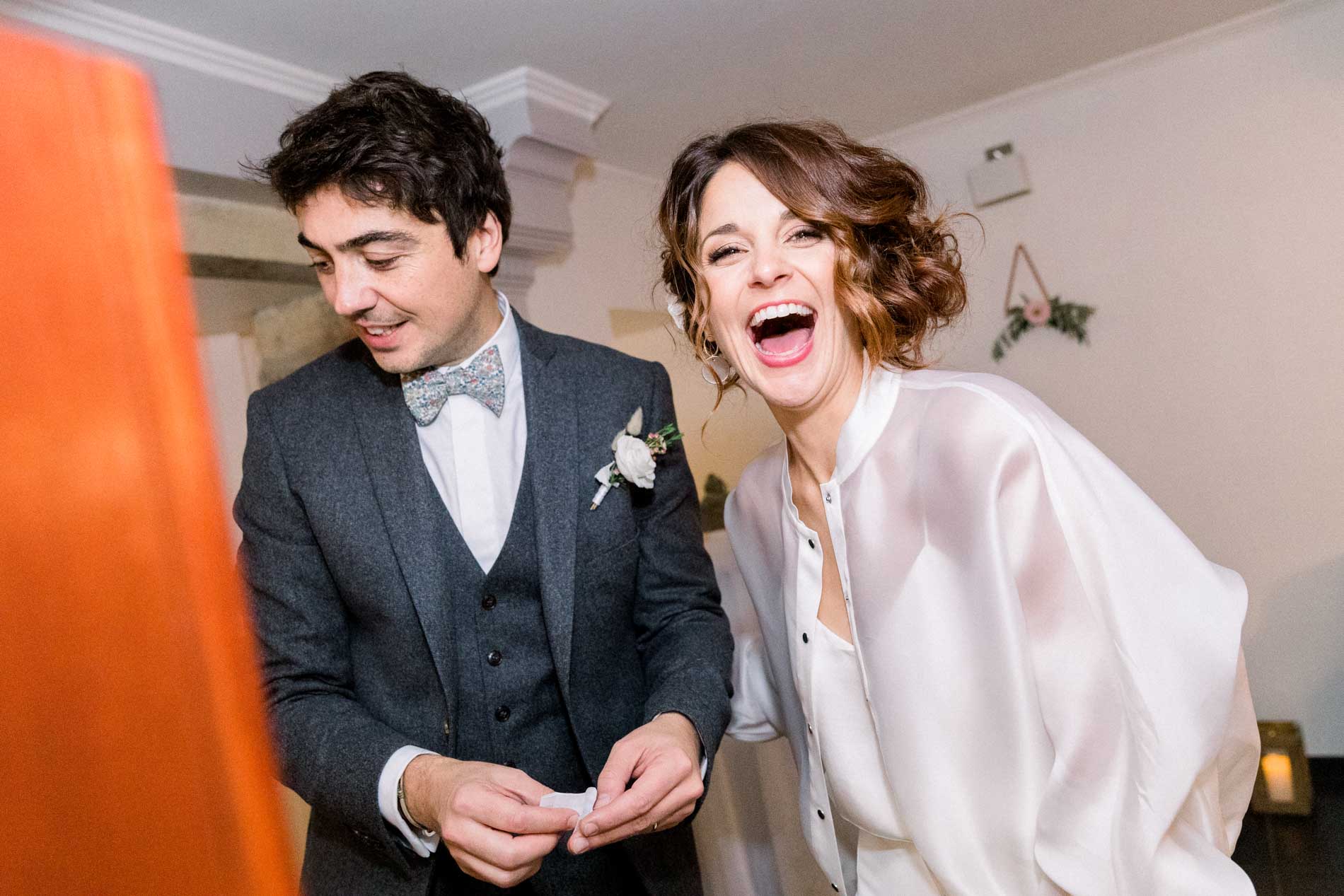The bride and groom bursting into laughter as they arrive at cocktail hour