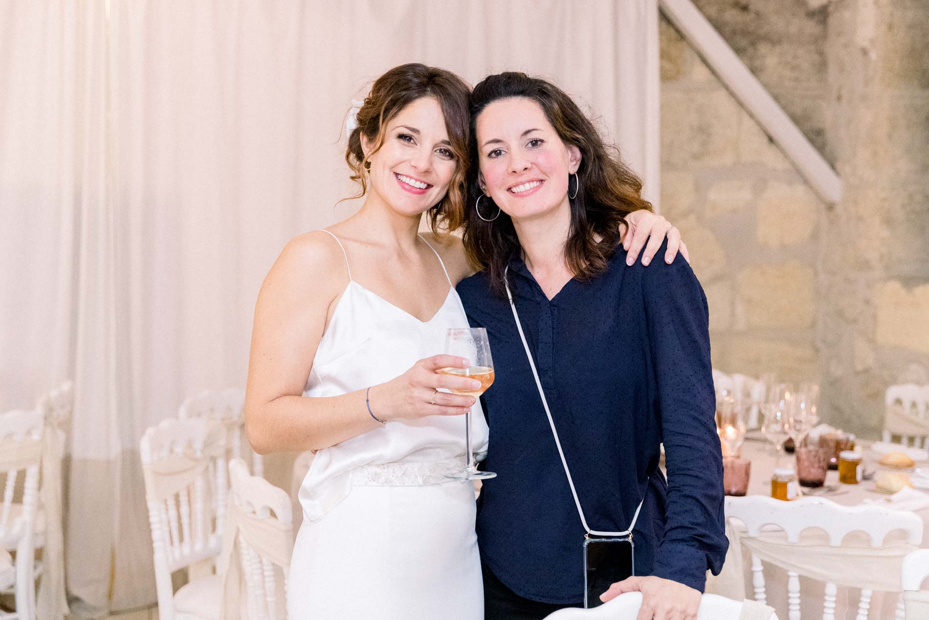 The bride posing with Alexandra Ambert in the reception room