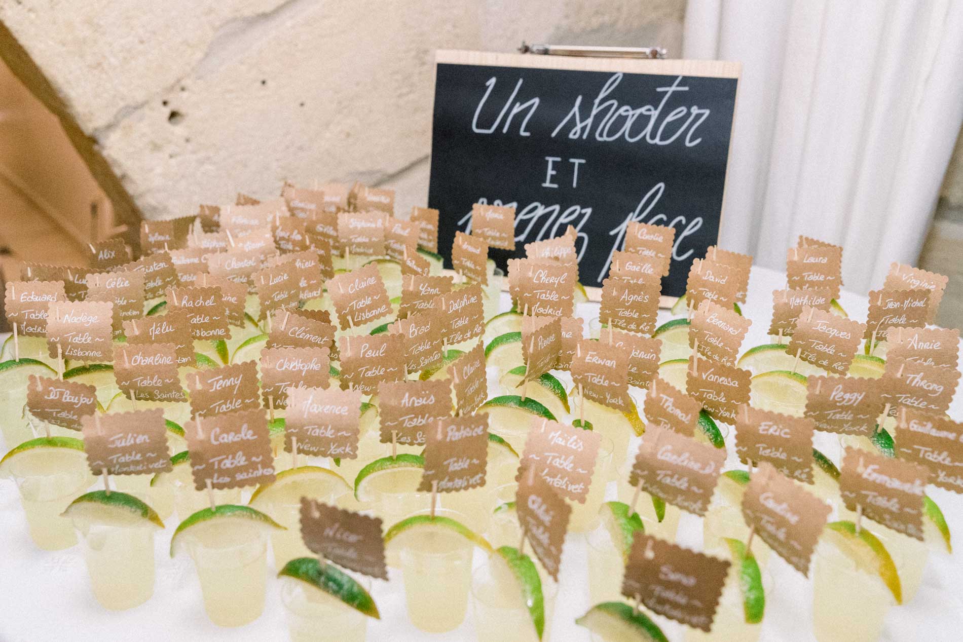 Lime shot glasses lined up beneath a chalkboard sign at the party